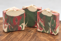 Mistletoe Lane handmade goat milk soap bars with muted red, green, and cream swirls